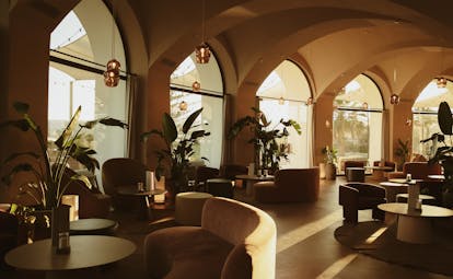 La Zambra Resort Bamboleo Restaurant interior with arched windows and sofa-style seating