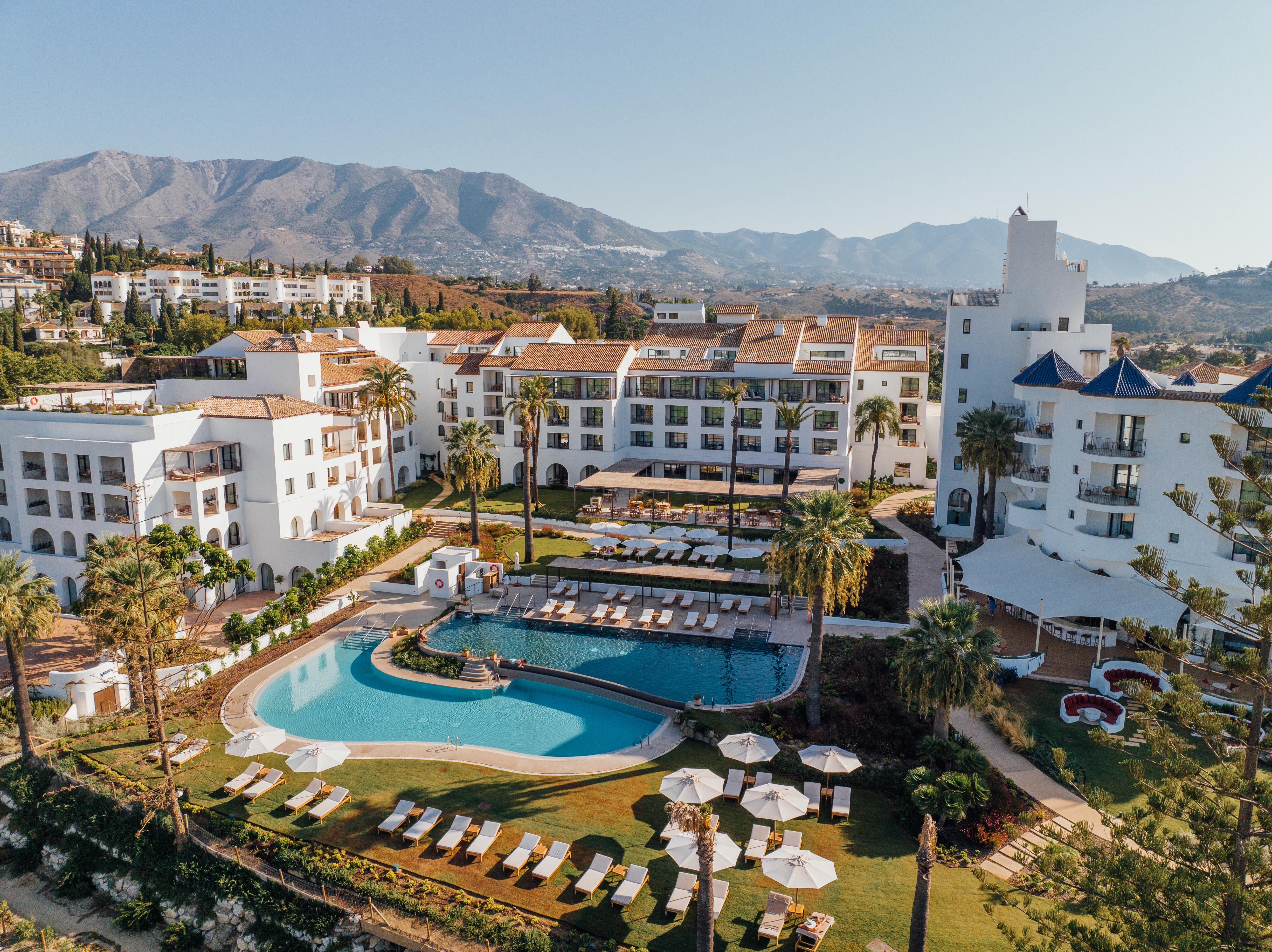 La Zambra Resort aerial view of white hotel buildings and pools with mountains in the distance