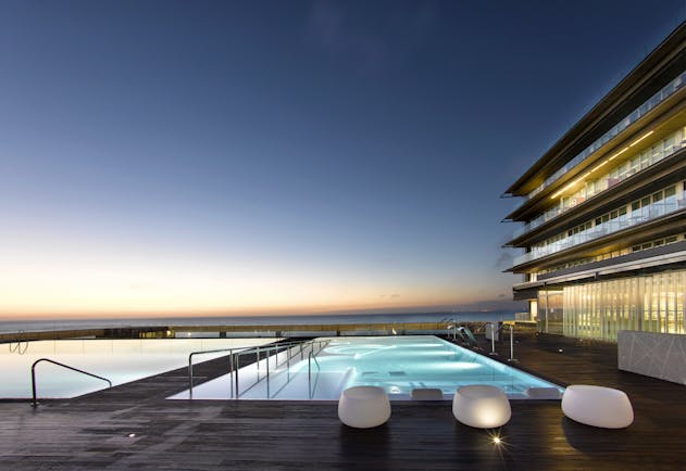 Parador de Cadiz Hotel Atlantico poolside, decking, pool lit up at night, terrace overlooking sea
