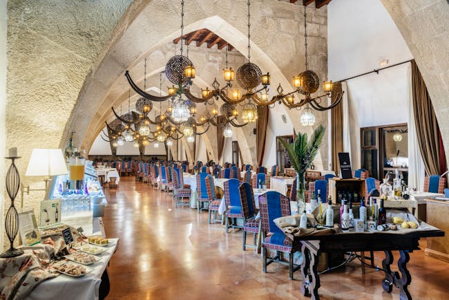 Parador de Jaen arcaded dining room with chandeliers and blue backed chairs