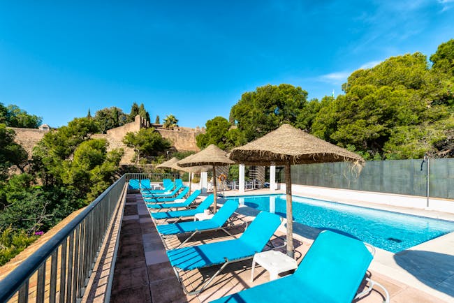 Parador de Malaga Gibralfaro pool, sun loungers, pine trees in background