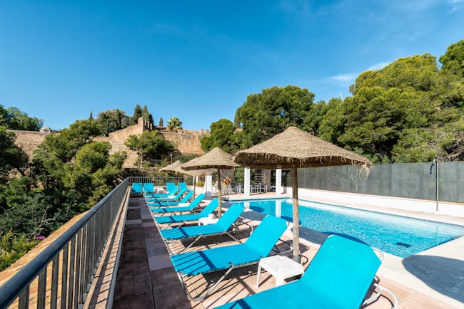 Parador de Malaga Gibralfaro pool, sun loungers, pine trees in background