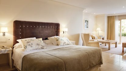 Puente Romano Marbella deluxe junior suite bed lounge area modern décor