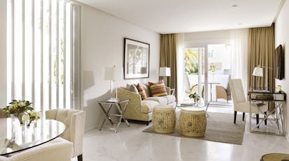 Puente Romano Marbella deluxe two bedroom suite living area sofa chairs balcony