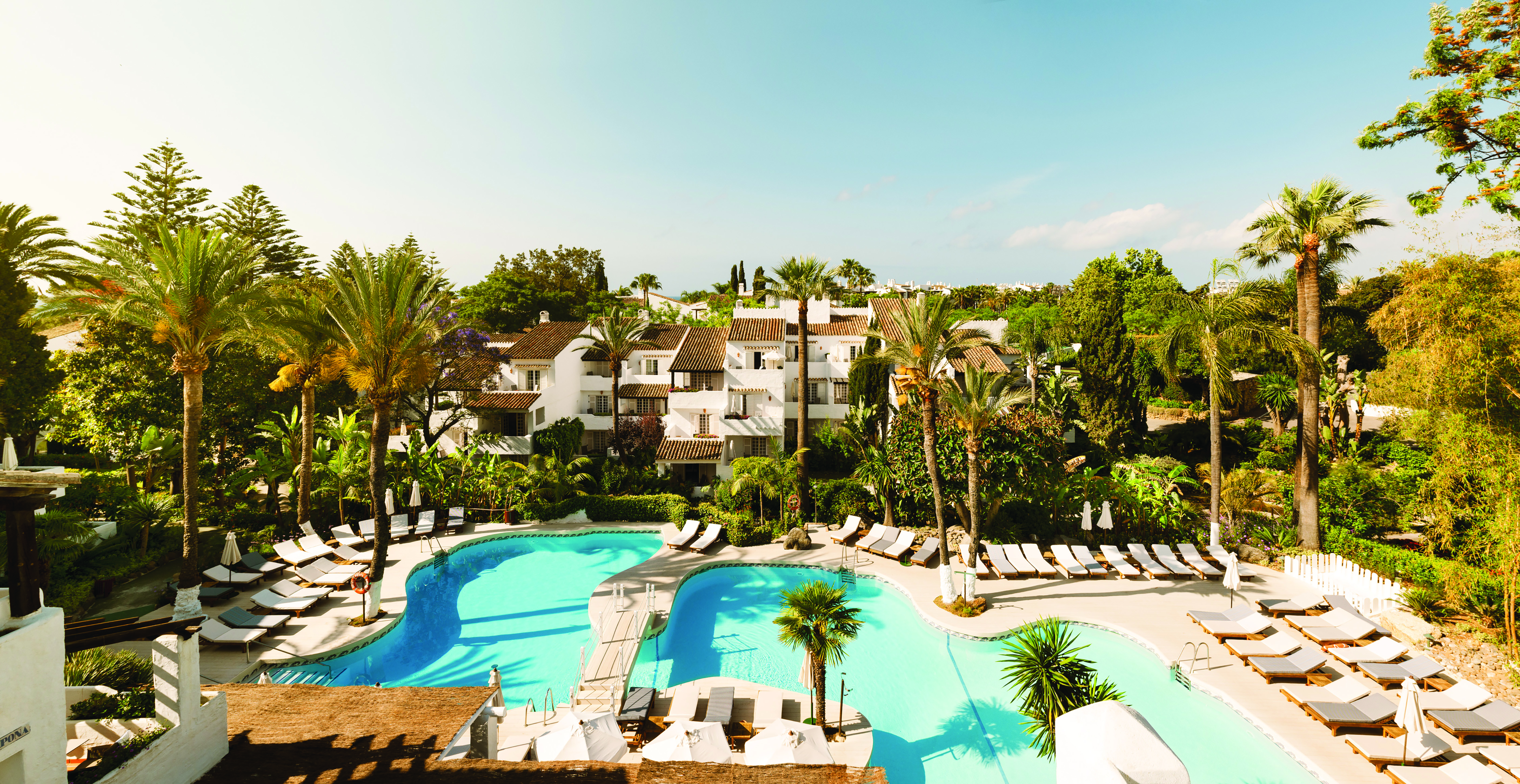 Puente Romano Marbella pool sun loungers palm trees 