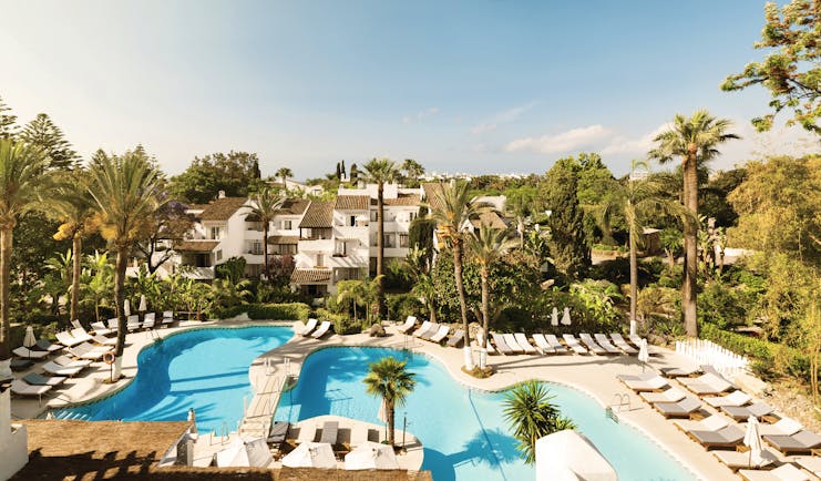 Puente Romano Marbella pool sun loungers palm trees 