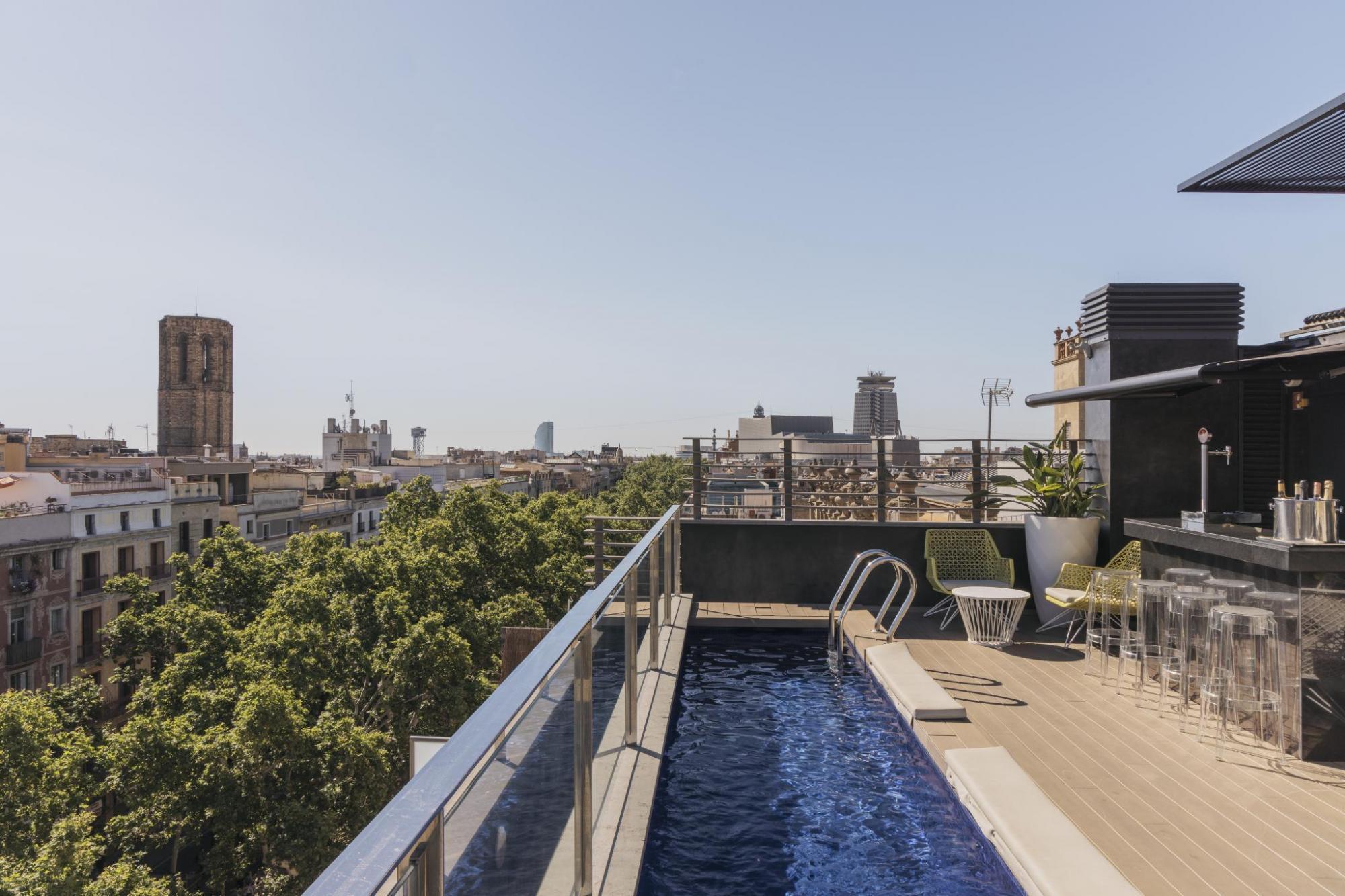 Hotel Bagues rooftop lane swimming pool overlooking the green cityscape of Barcelona