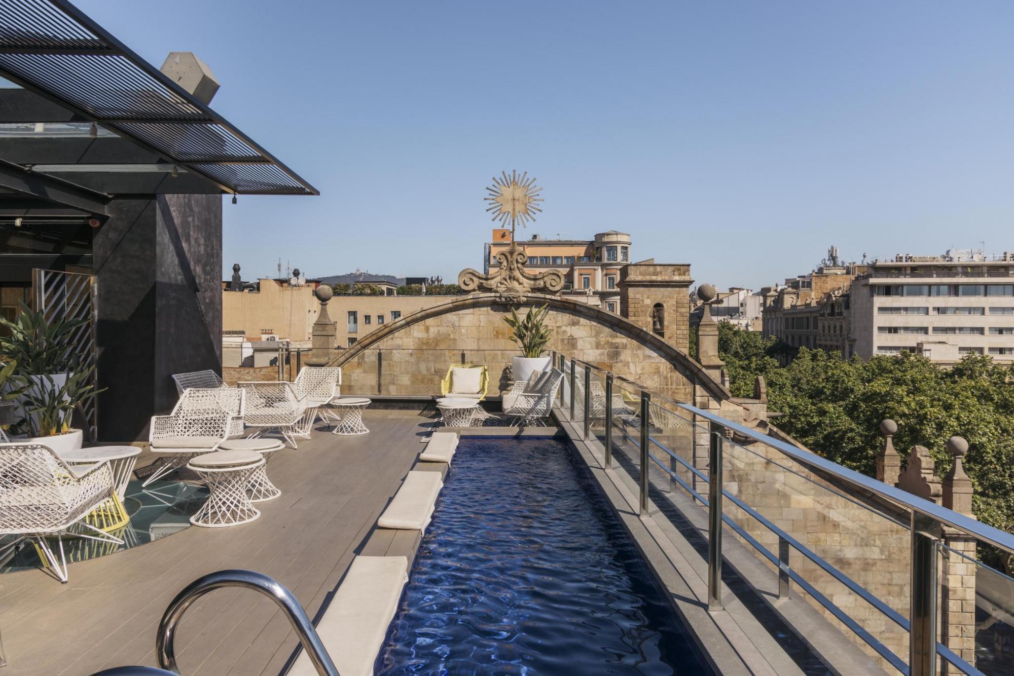 Hotel Bagues rooftop pool terrace, with bar seating and views of the city