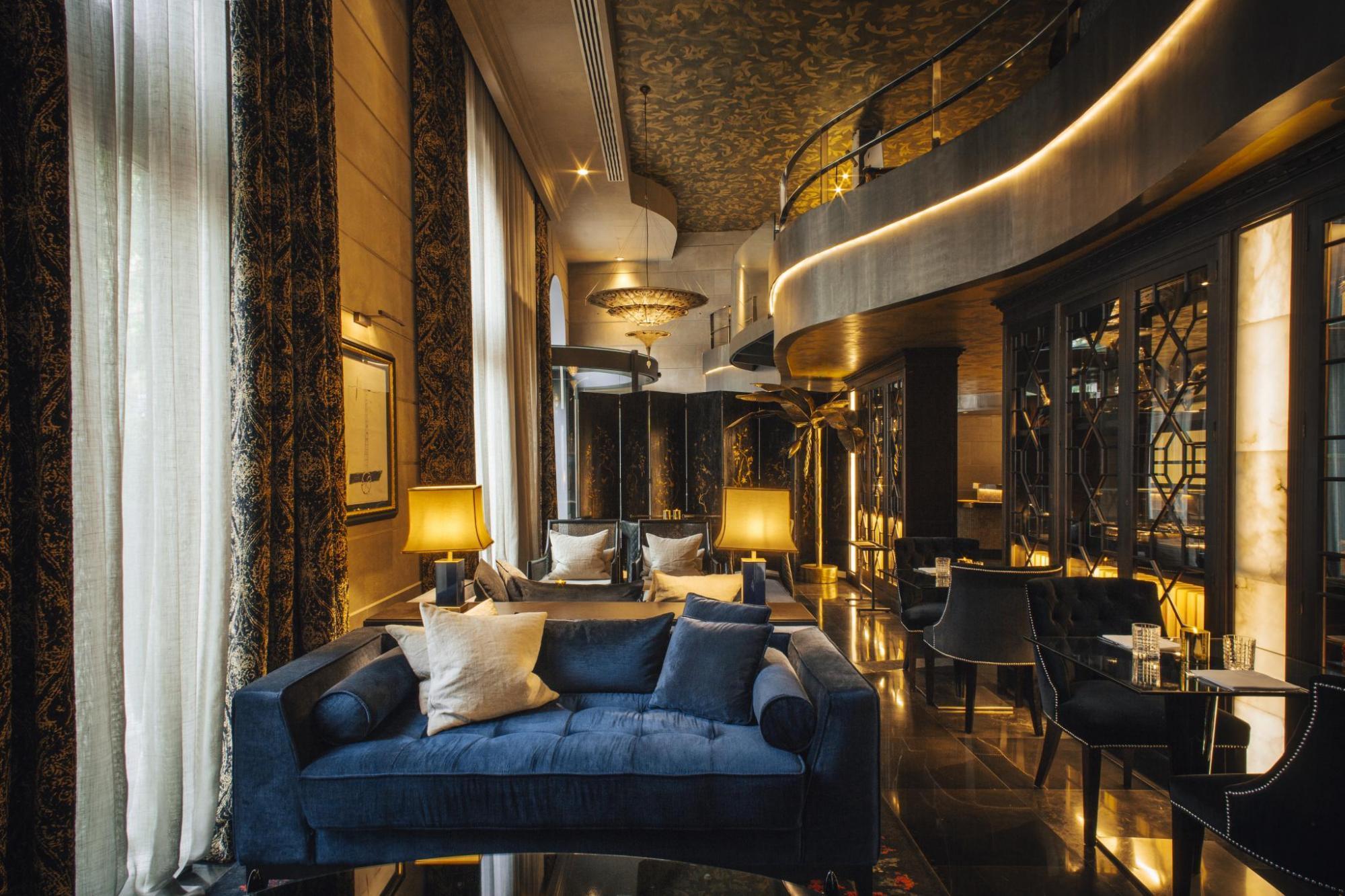 Hotel Bagues Restaurant with dark, rich decor, plush blue sofa, and gold lighting to set the ambience