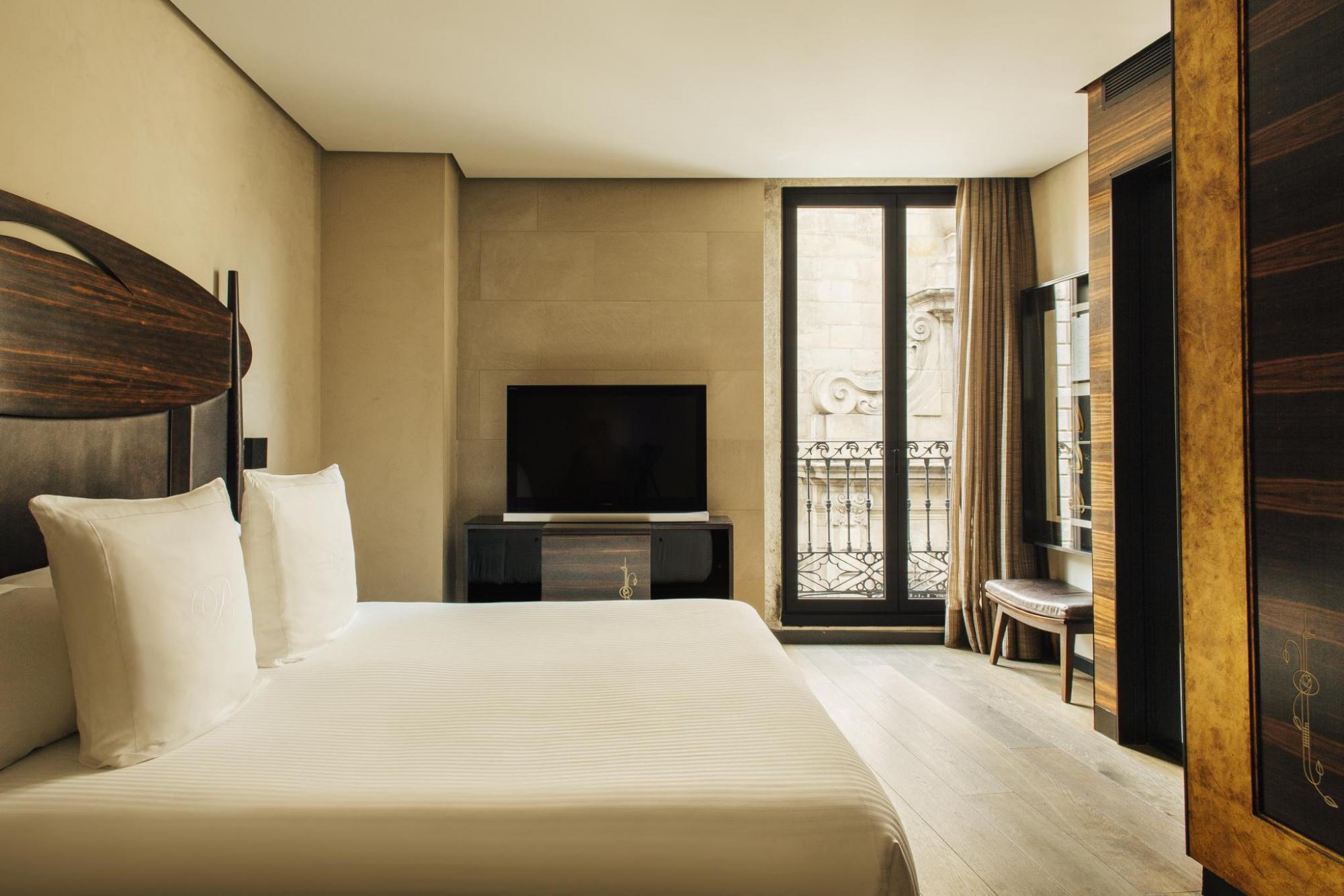 Hotel Bagues Superior Room with warm neutral colour palette, tall windows and juliet balcony, and wooden furnishings