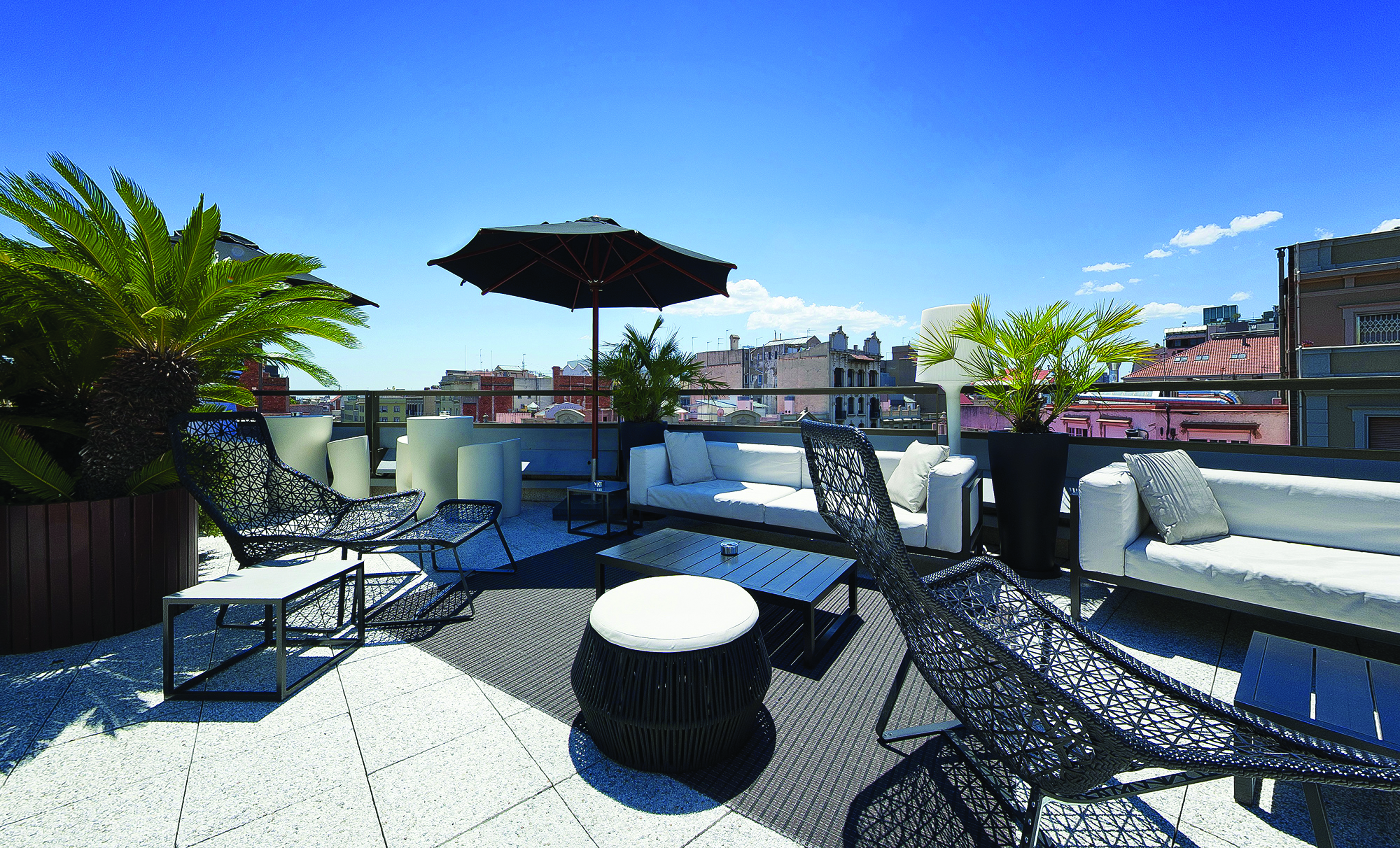 Hotel Claris Barcelona terrace rooftop seating area loungers umbrella city views