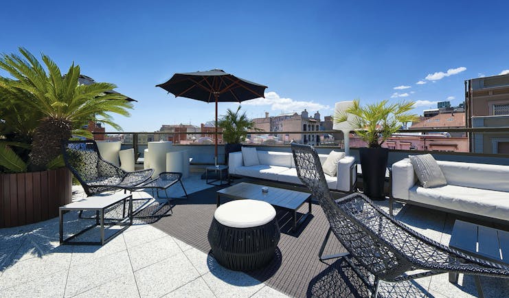 Hotel Claris Barcelona terrace rooftop seating area loungers umbrella city views