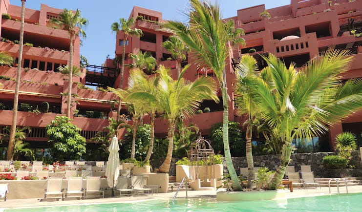Abama Tenerife family pool sun loungers pal trees hotel in background