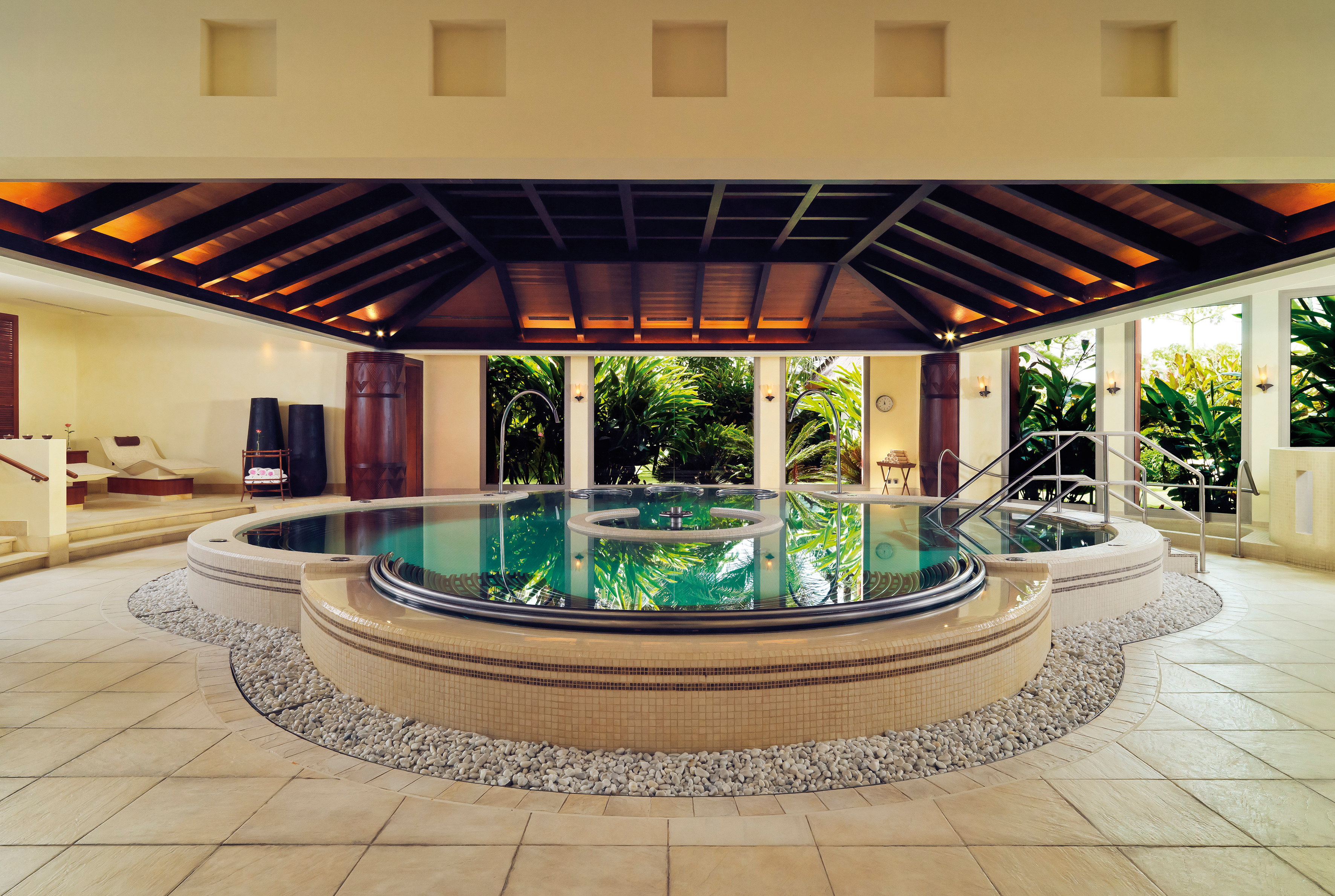 Indoor pool spa area with wood pannelled ceiling and circular pool