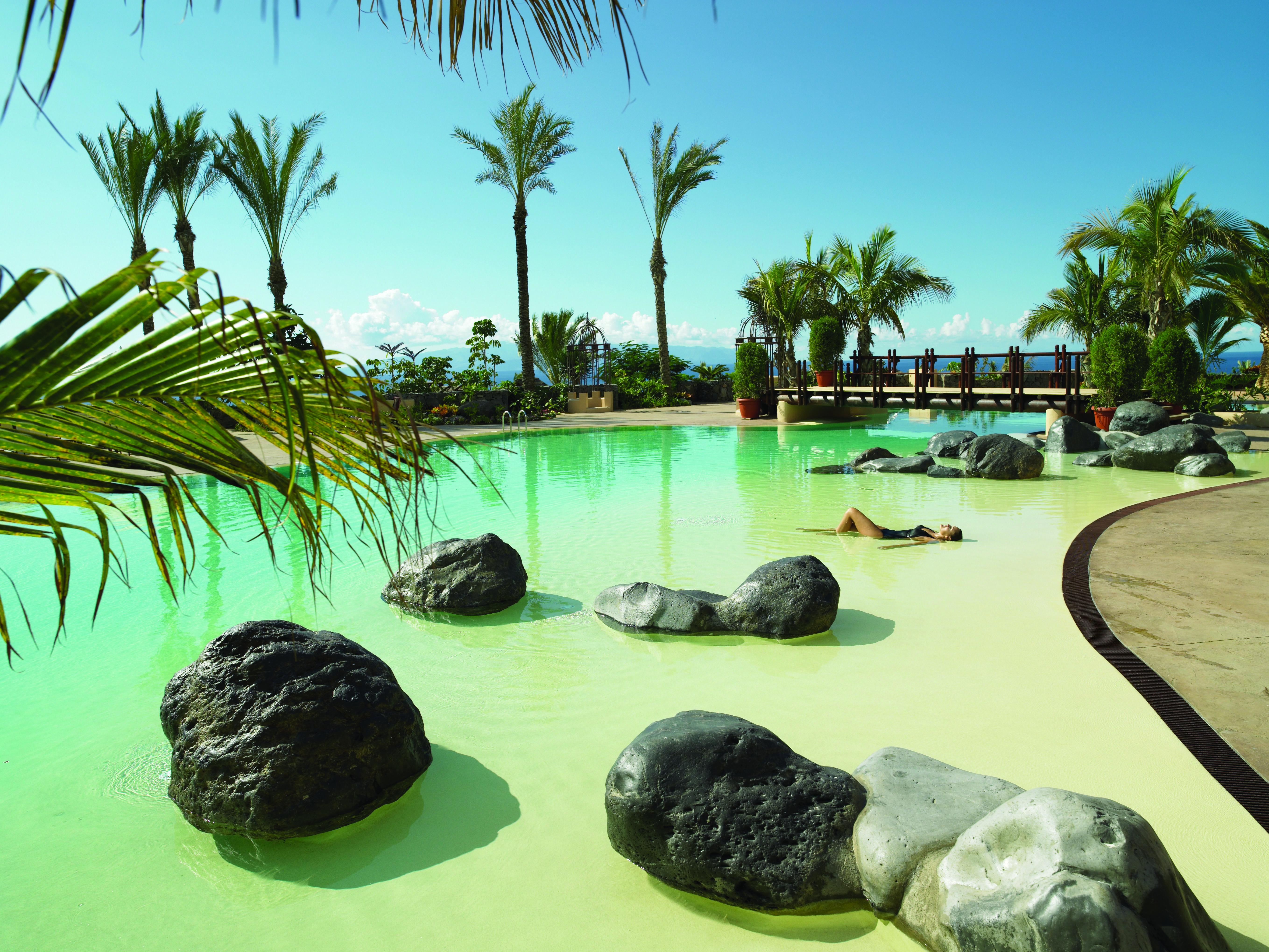Abama Tenerife pool terrace palm trees rocks in water