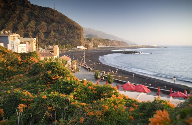 Black sand beach with white houses on land near Los Llanos de Aridane on La Palma in the Canaries