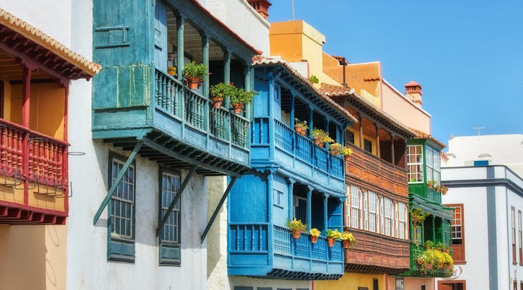Galleried houses with balconies of pot plants all painted different colours in Santa Cruz de la Palma