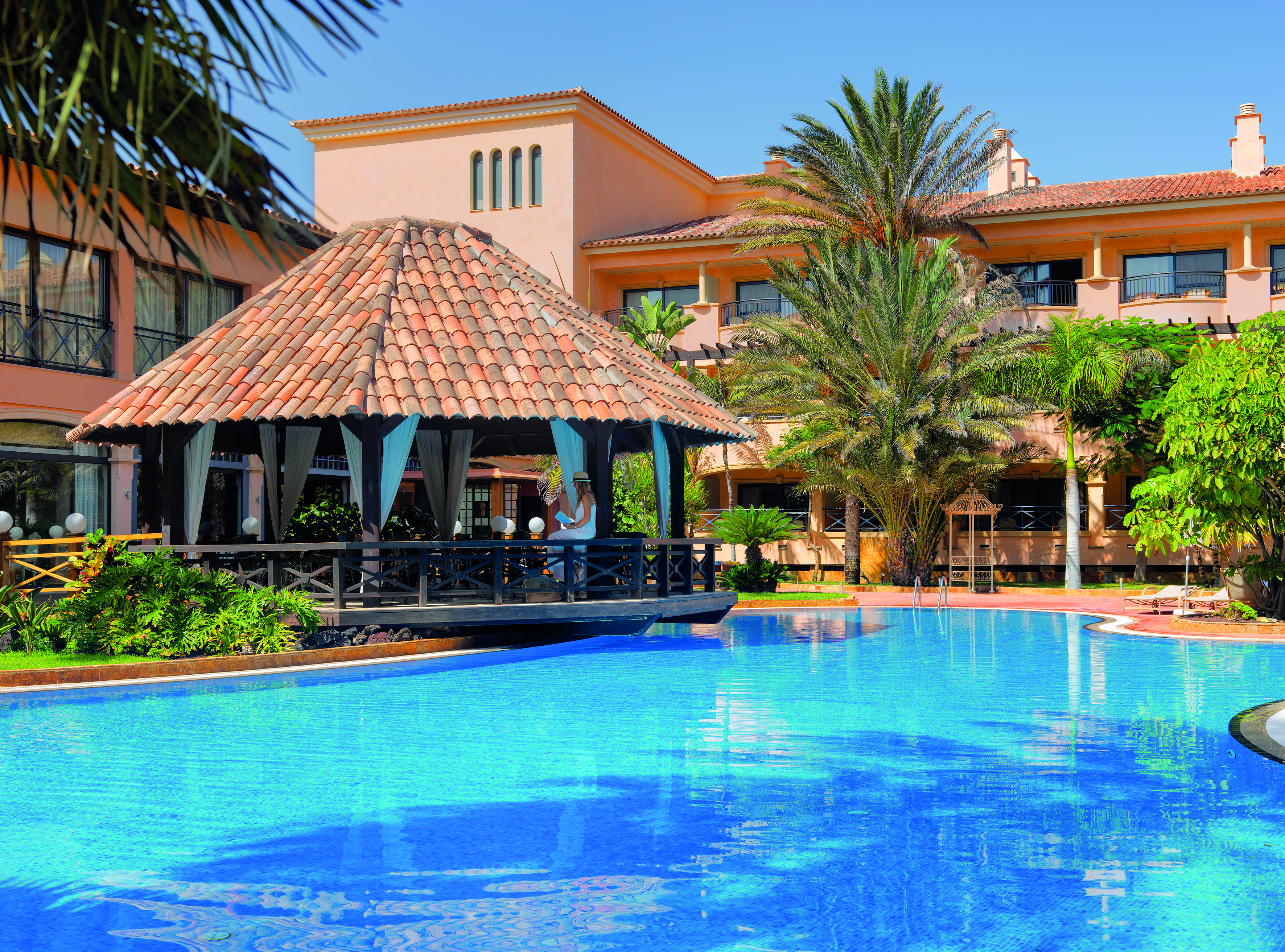 Gran Hotel Atlantis Bahia Fuerteventura pool side covered seating area palm trees