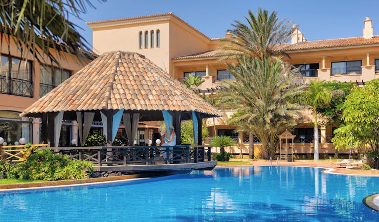 Gran Hotel Atlantis Bahia Fuerteventura pool side covered seating area palm trees