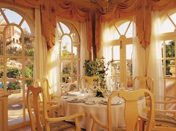 Indoor restaurant with gold colour scheme and draping curtains