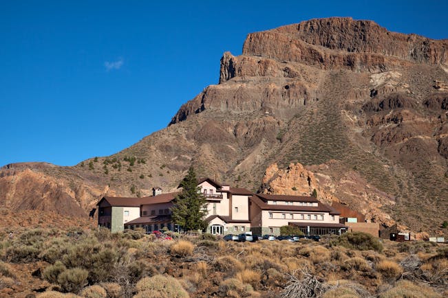 Exterior of hotel shown in front of huge mountain