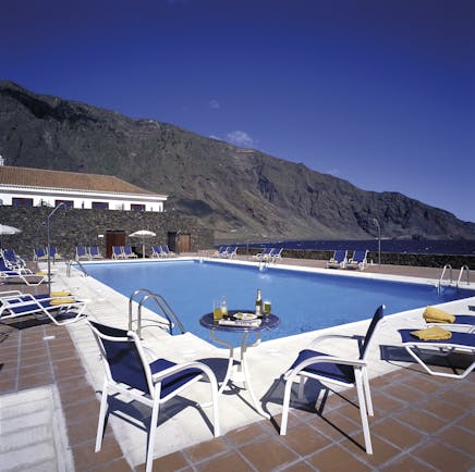 Parador de el Hierro Canary Islands pool sun loungers overlooking beach mountains in background