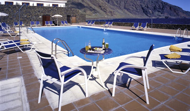 Parador de el Hierro Canary Islands pool sun loungers overlooking beach mountains in background