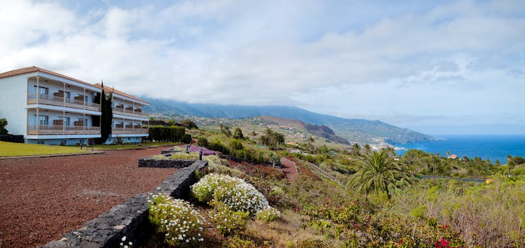 Exterior of hotel with white building and looking out over the gardens and sea