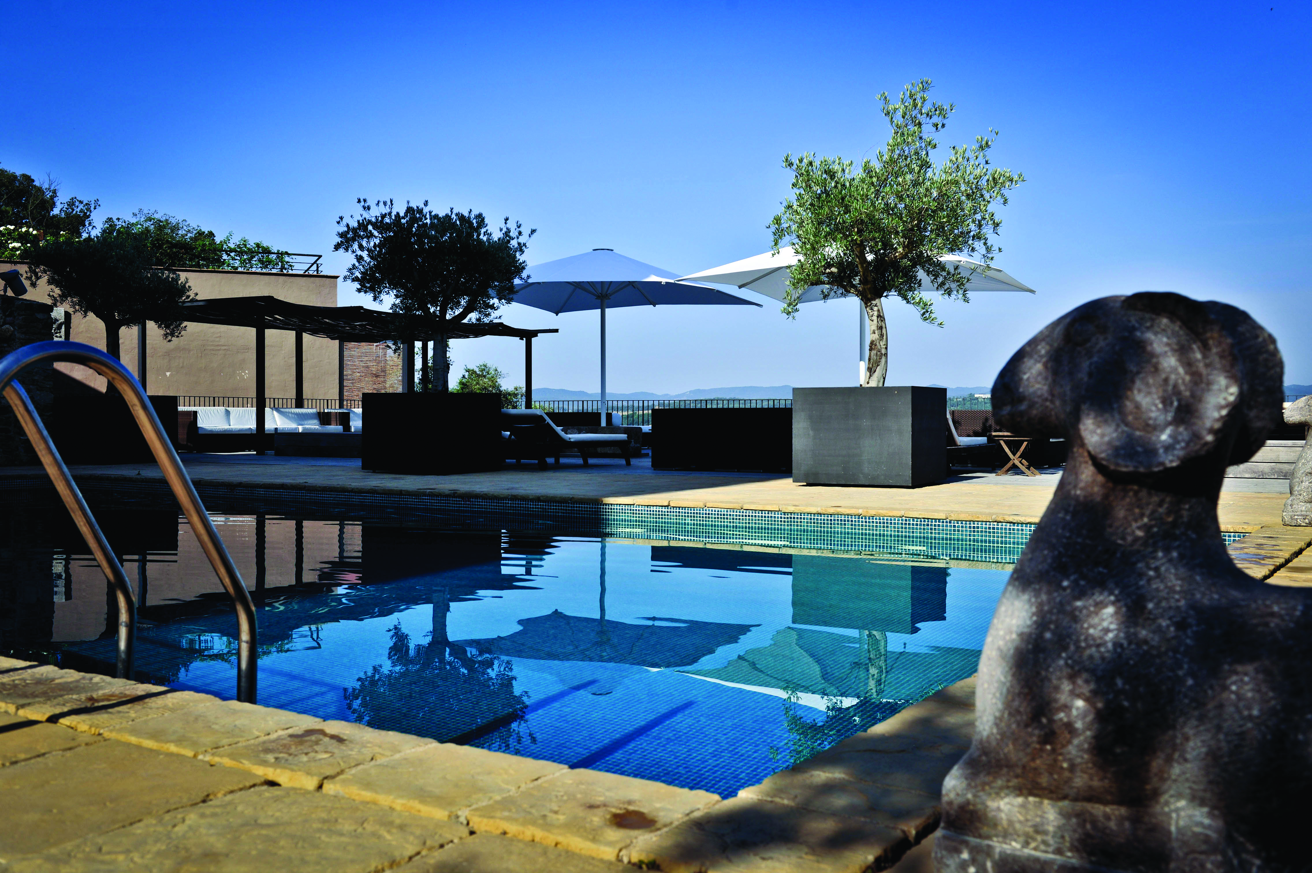 Castell D'Emporda Eastern Spain pool sun loungers umbrellas trees