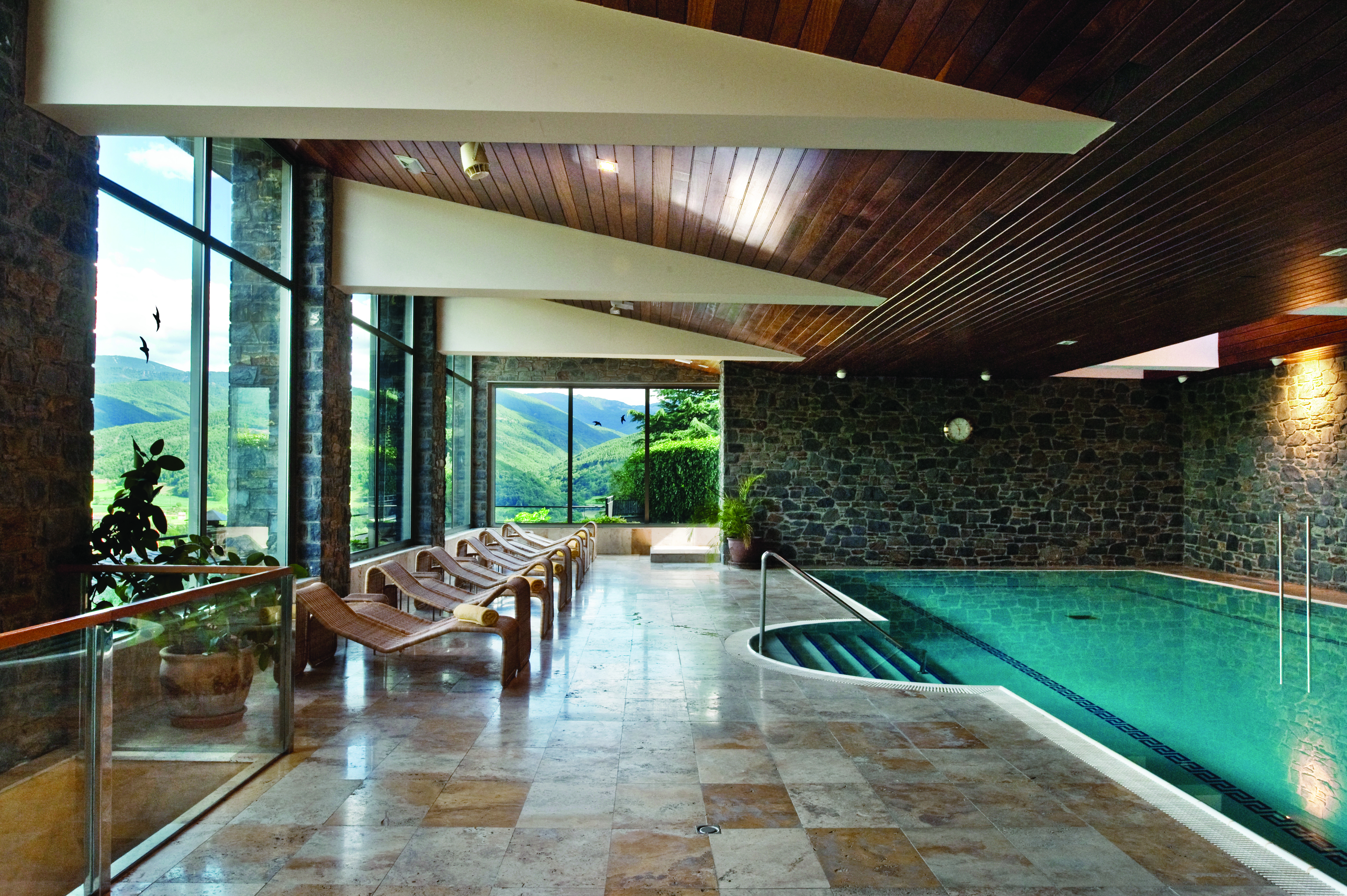 Hotel el Castell de Ciutat Catalonia indoor pool loungers tiled floors large glass doors mountains views