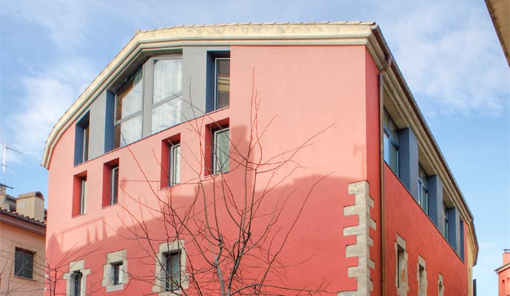 Exterior of hotel with pink and grey building with rectangular windows