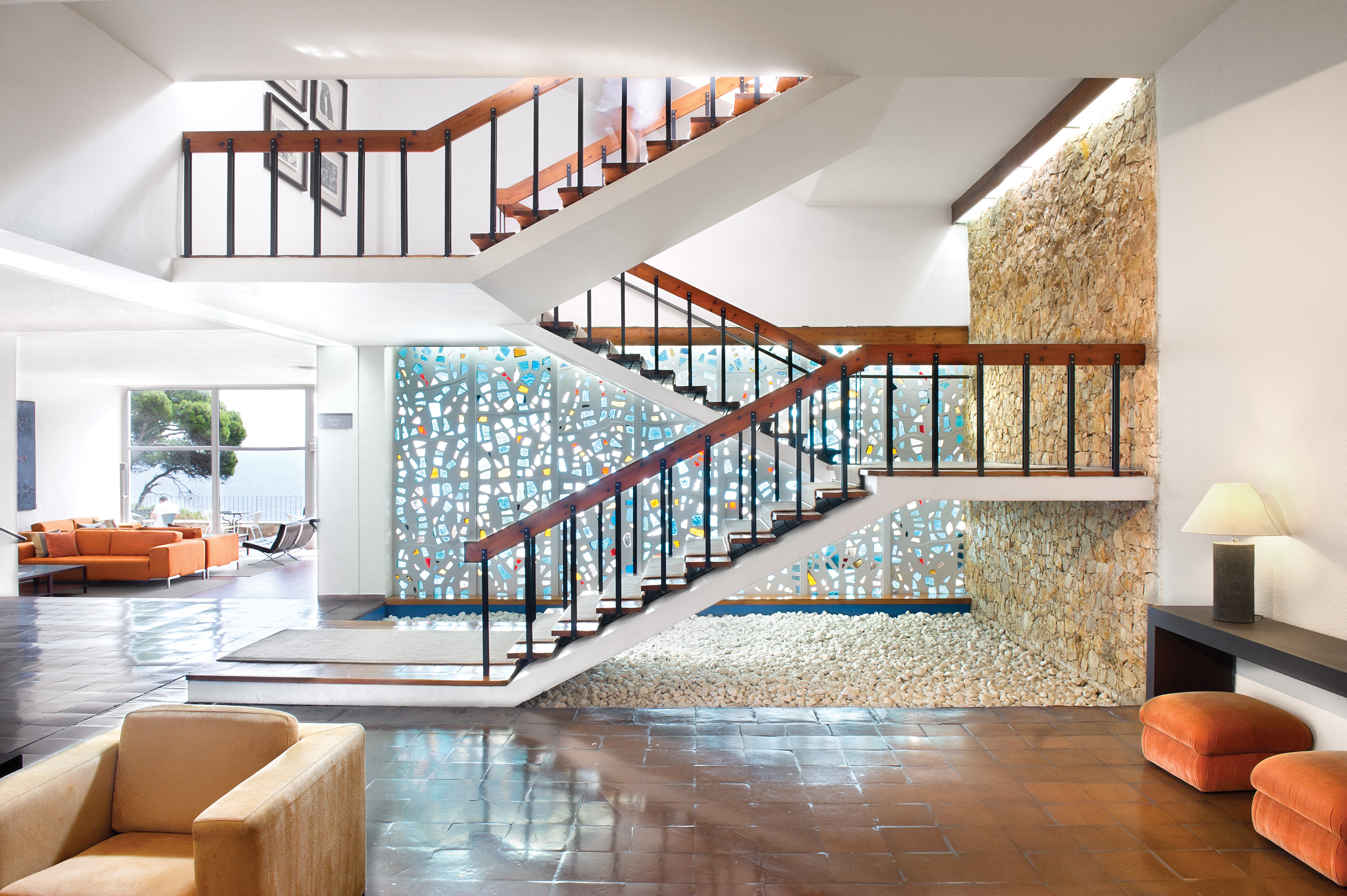 Interior hallway of hotel with lounge in background and stairs leading upstairs