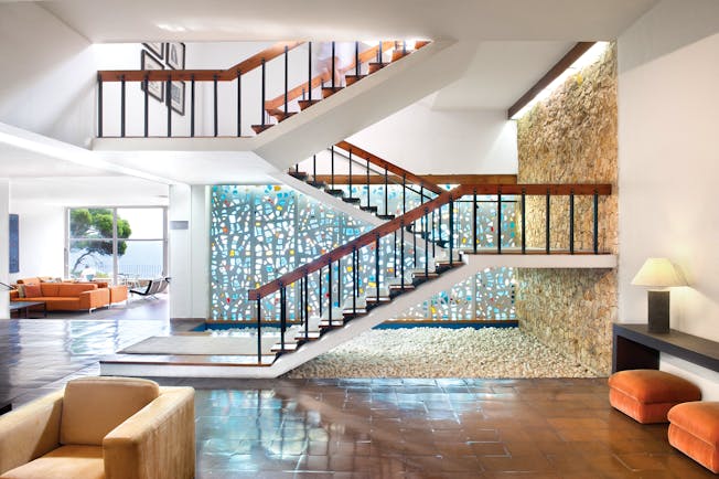 Interior hallway of hotel with lounge in background and stairs leading upstairs