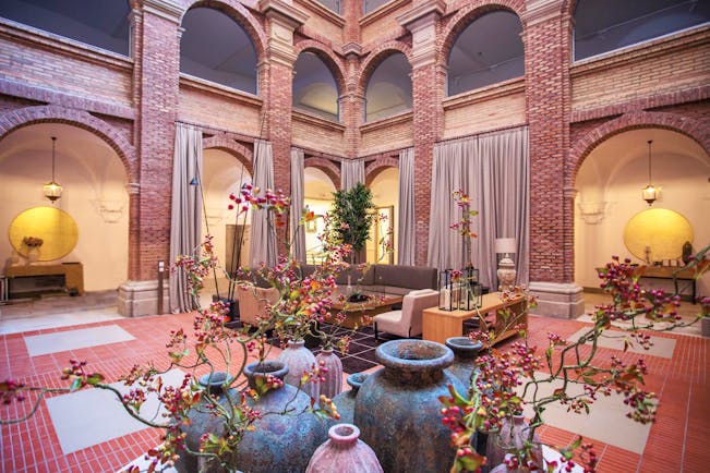 Parador de Lleida lobby, sofas, plants, exposed brick decor, red tiles