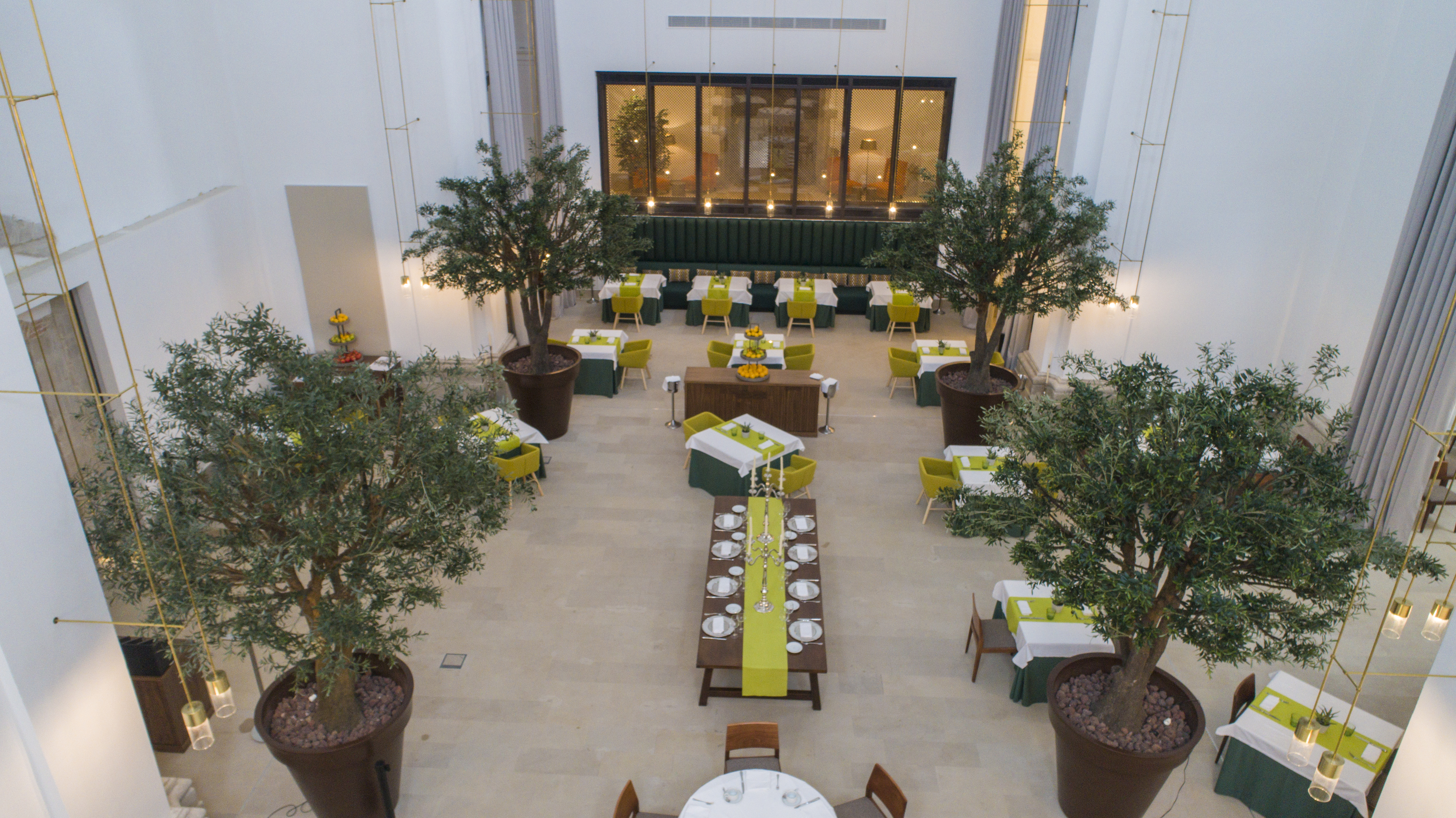 Parador de Lleida restaurant, dining tables, chairs, indoor trees, elegant decor