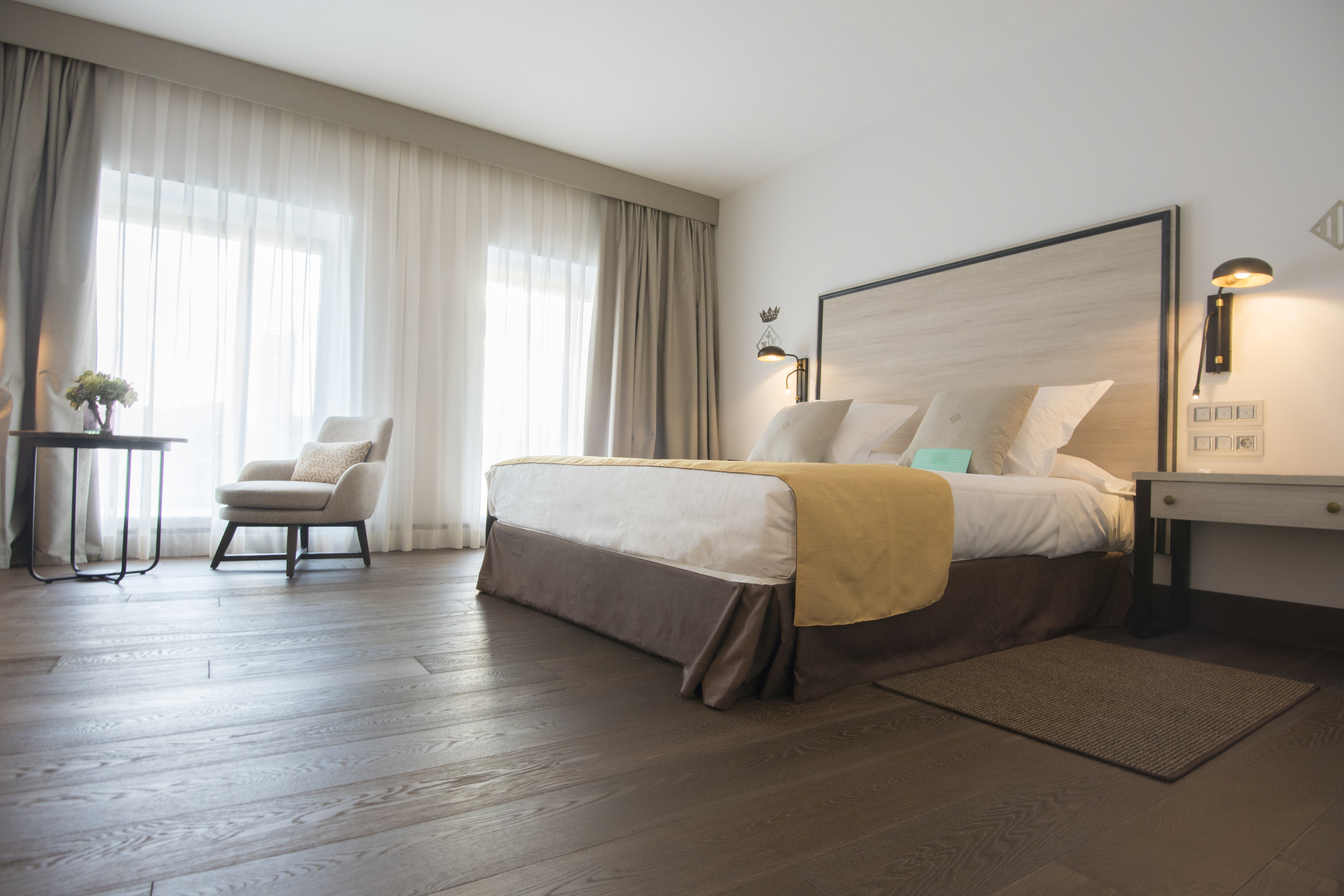 Parador de Lleida standard room, double bed, chair, large windows, pine floors and furniture