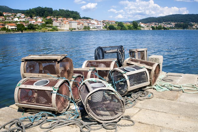 Lobster pots on quayside with blue sea behind in Pontevedra in the Rias Baixas in Galicia