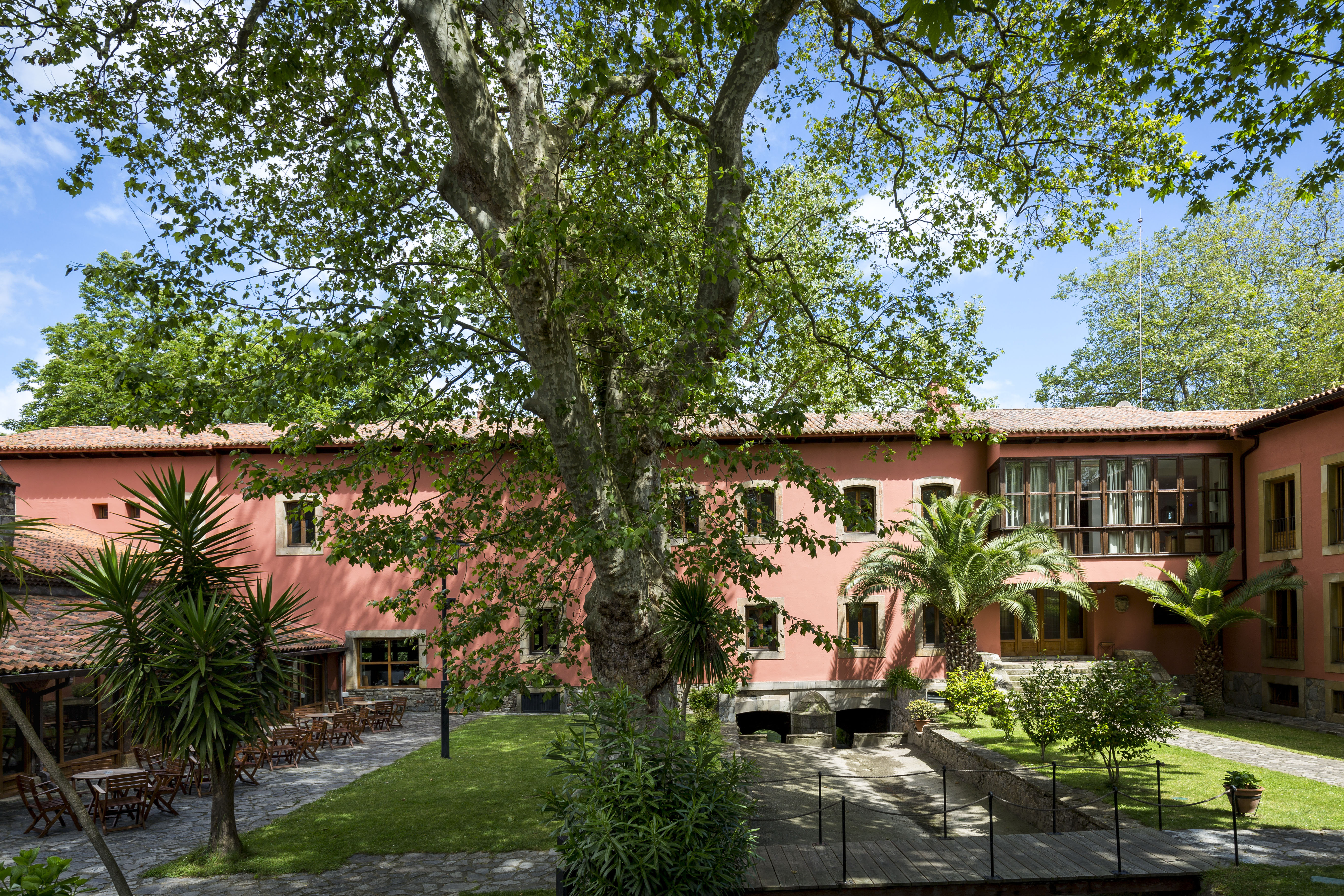 Parador de Gijon garden, lawn, trees, hotel building