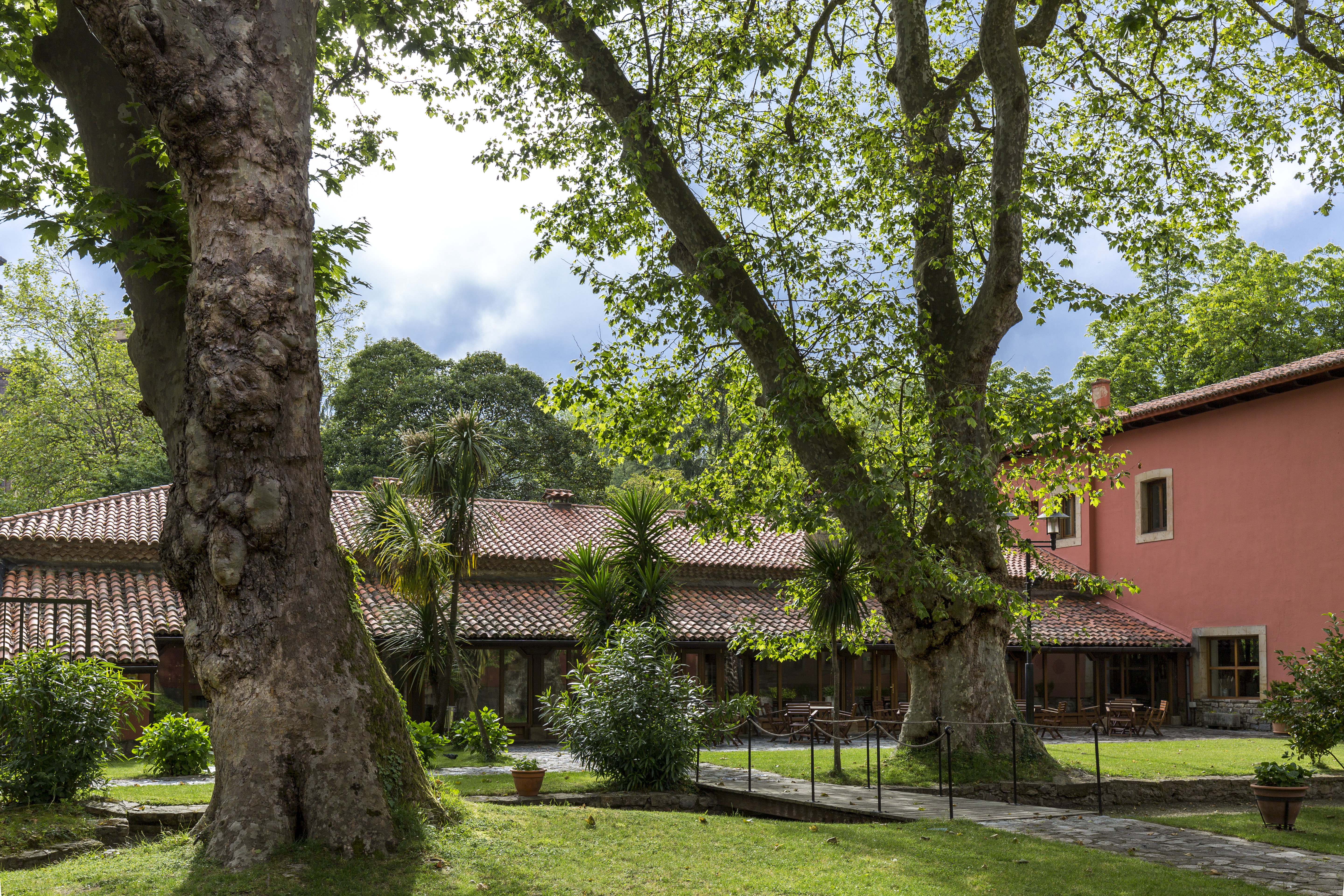 Parador de Gijon grounds, lawns, trees, hotel buildings in background
