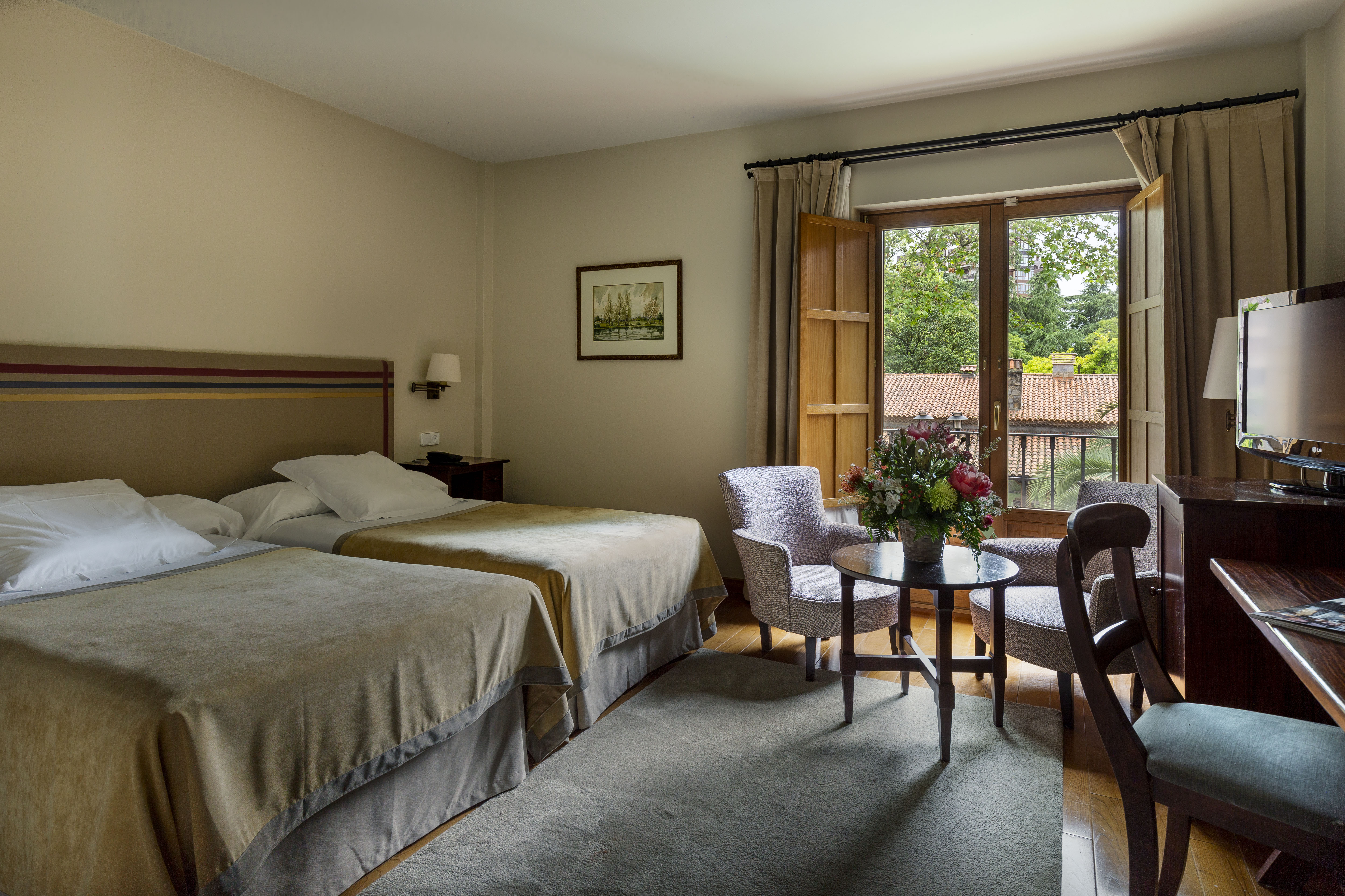 Parador de Gijon standard room, twin beds, table and chair, traditional decor