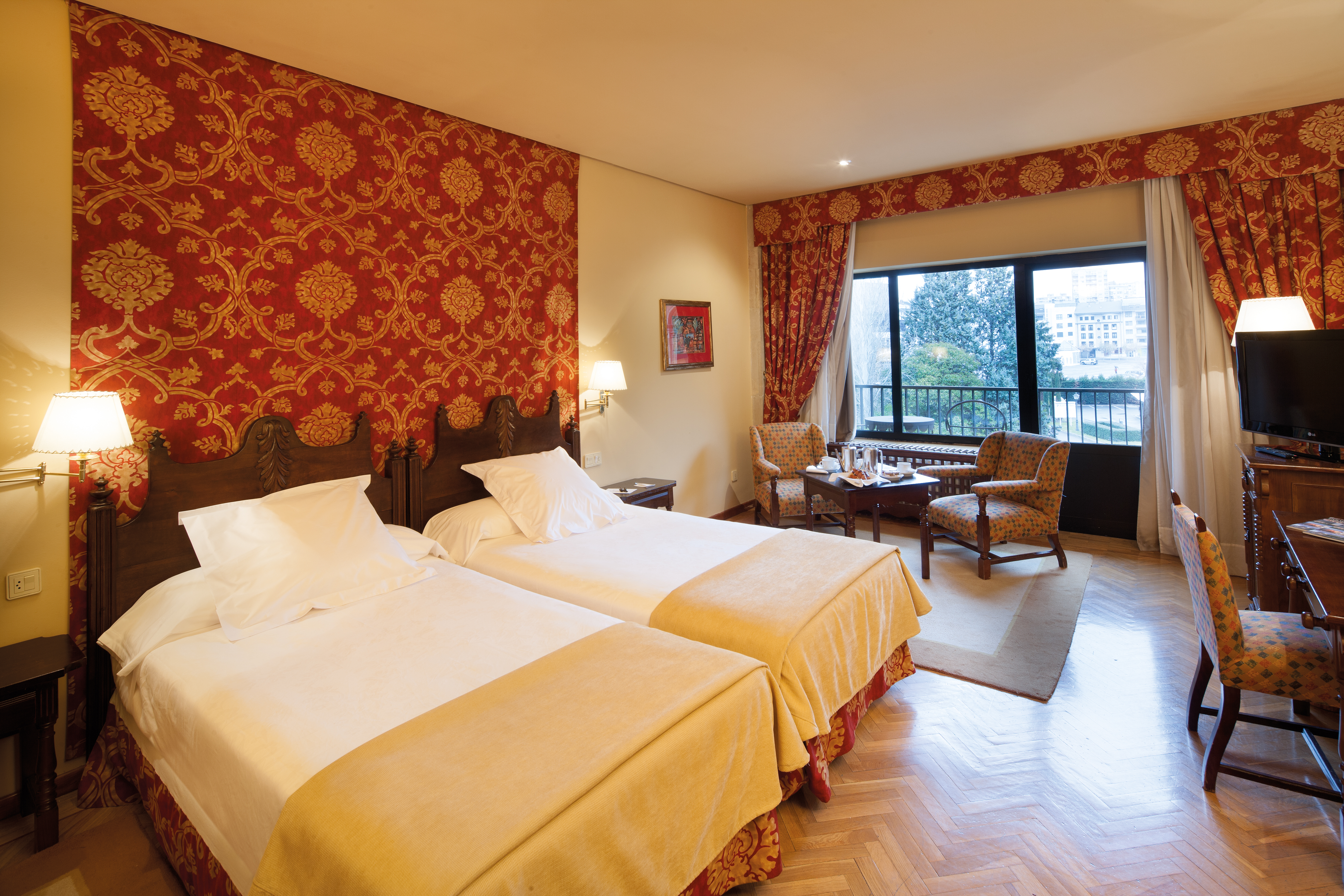 Twin room with two beds, seating area and television