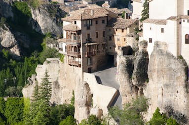 Houses with wooden balconies overhanging each other on the cliff sides of the gorge in Cuenca