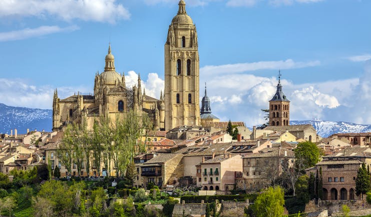 Tall spire and towers of the cathedral and city centre buildings from a distance at Segovia