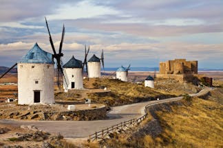 Traditional white windmills with conical roofs in arid landscape of La Mancha