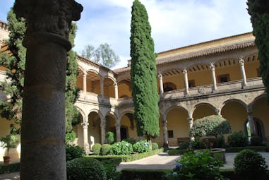 Arcaded loggia with beamed ceiling and terracotta roof of the monastery of Yuste overlooking courtyard gardens near Caceres