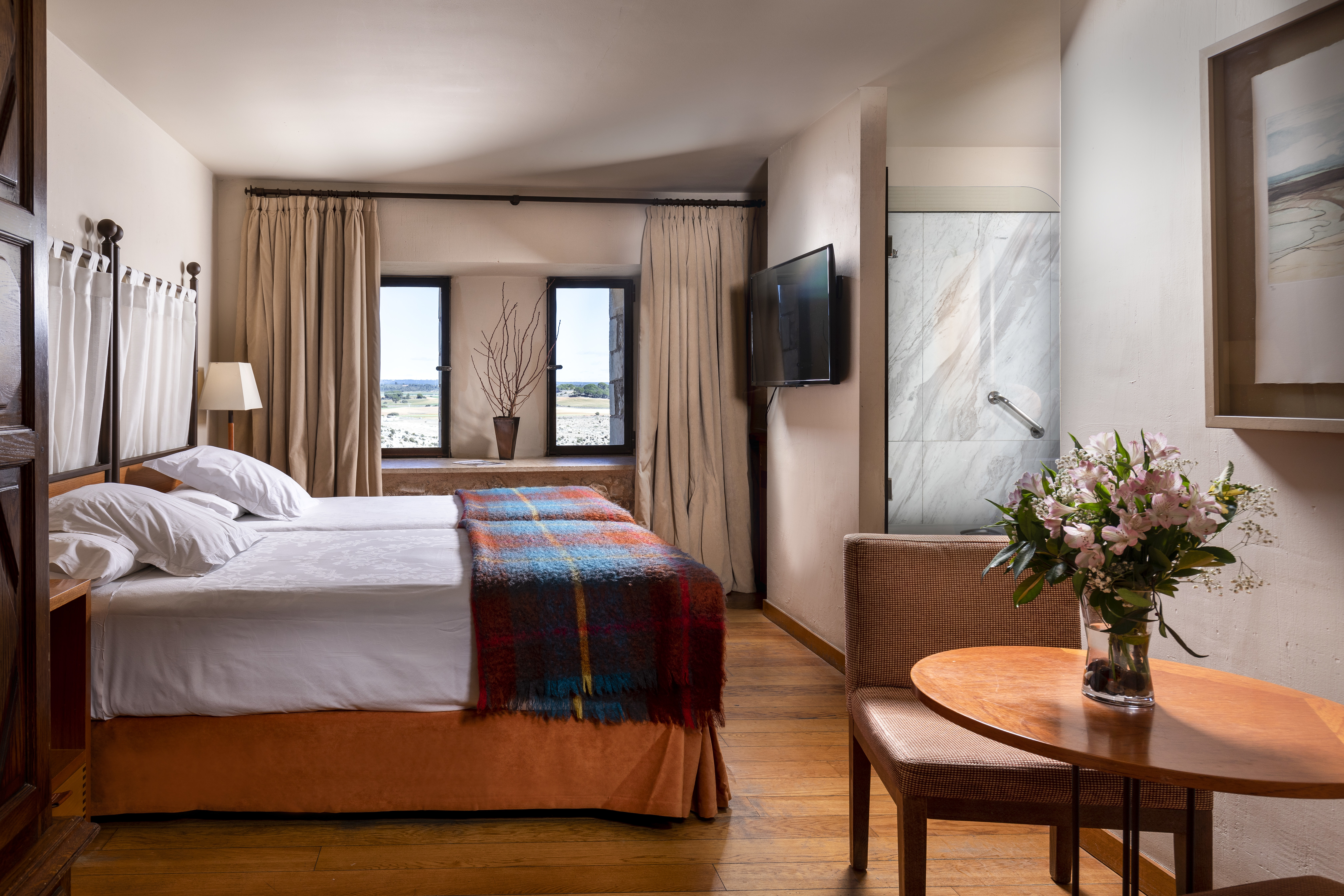 Parador de Alarcon twin bedroom with wooden floor and tweed blanket