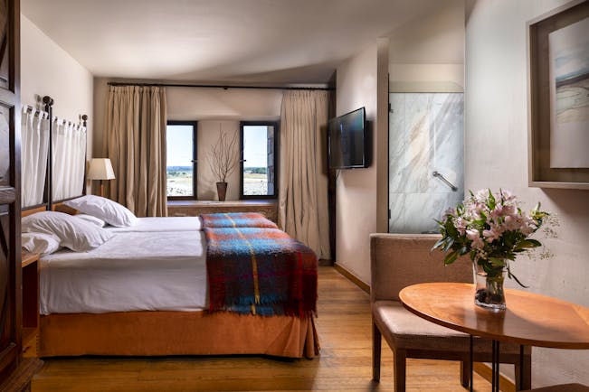 Parador de Alarcon twin bedroom with wooden floor and tweed blanket