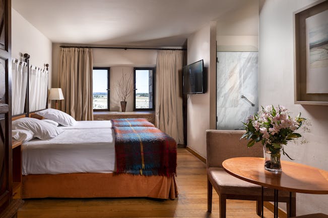 Parador de Alarcon twin bedroom with wooden floor and tweed blanket