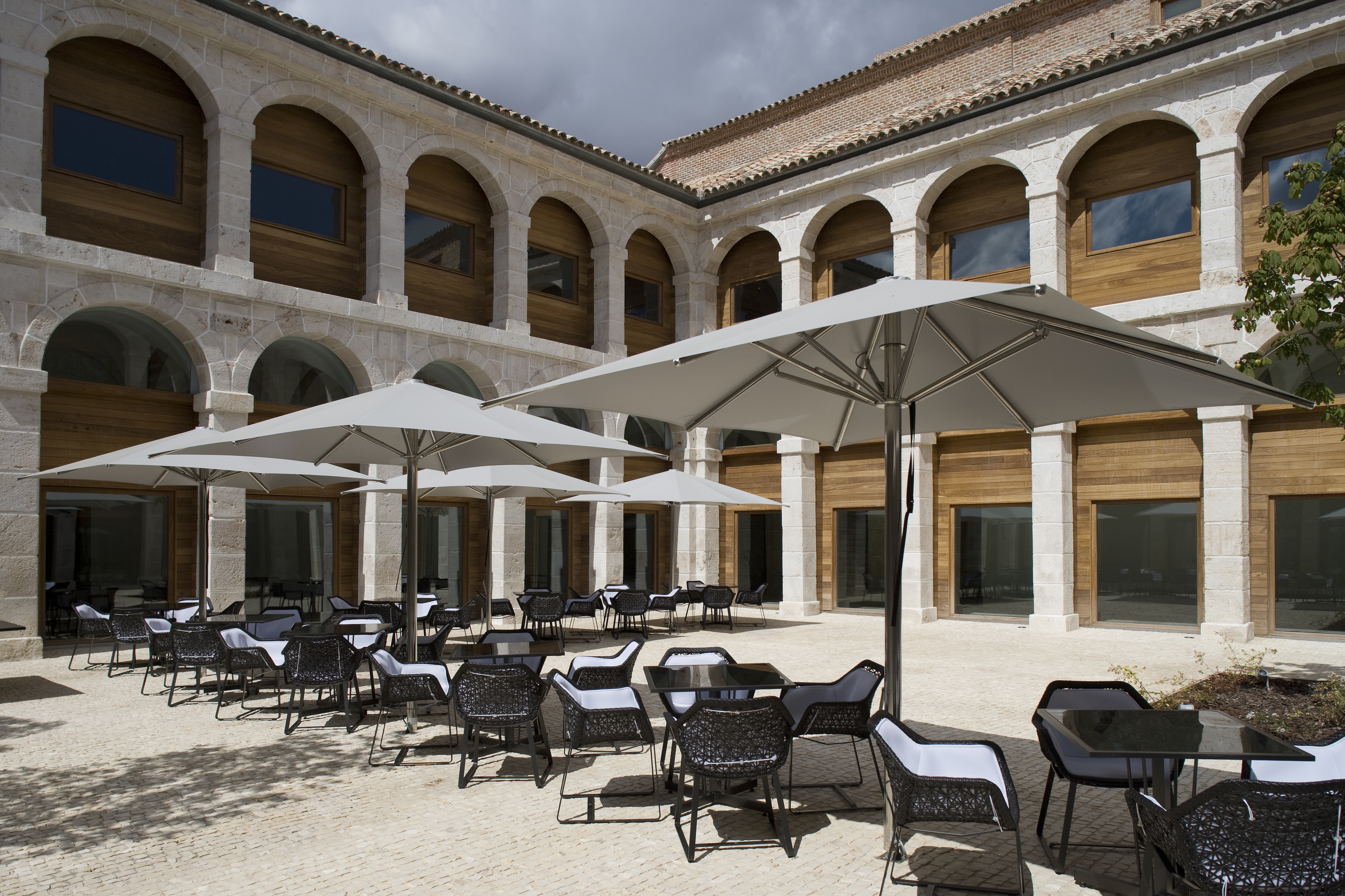 Parador de Alcala de Henares terrace, outdoor seating area, tables and chairs, hotel building