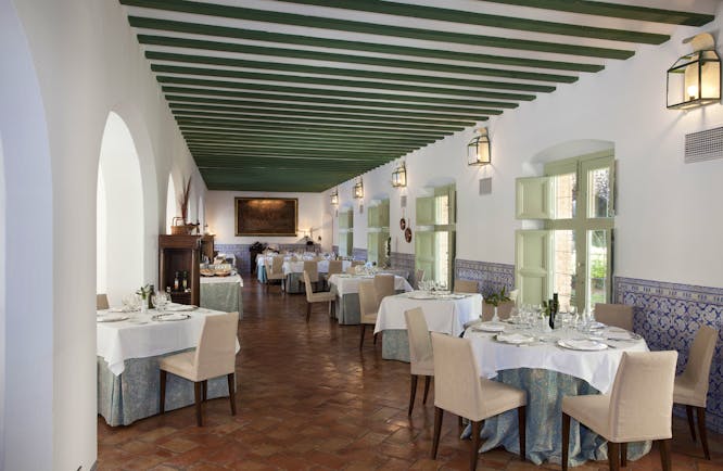 Parador de Almagro restaurant, dining tables, chairs, tiled floor, traditional architecture